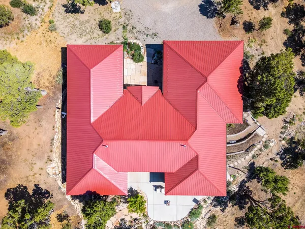 an aerial view of a house with an outdoor space and seating area