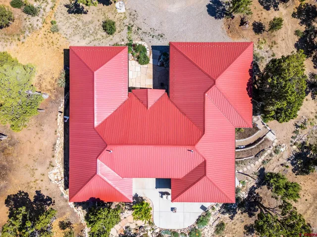 an aerial view of a house with an outdoor space and seating area