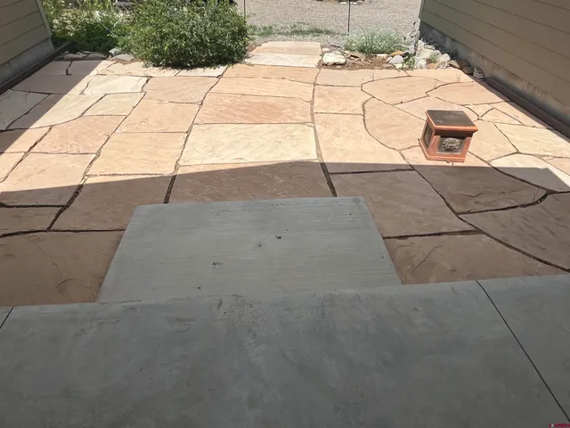 a dirty white building with a yard