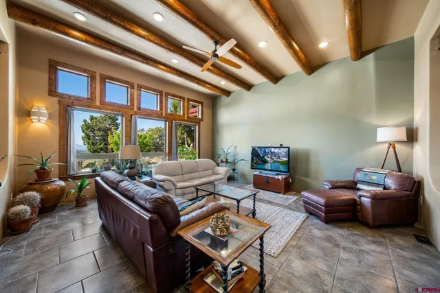 a living room with furniture a flat screen tv and a large window