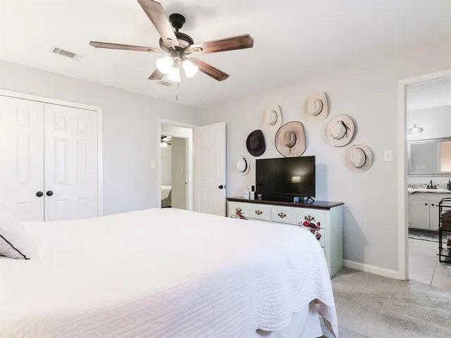 a big room with a bed and a chandelier fan
