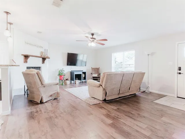 a living room with furniture a flat screen tv and a large window