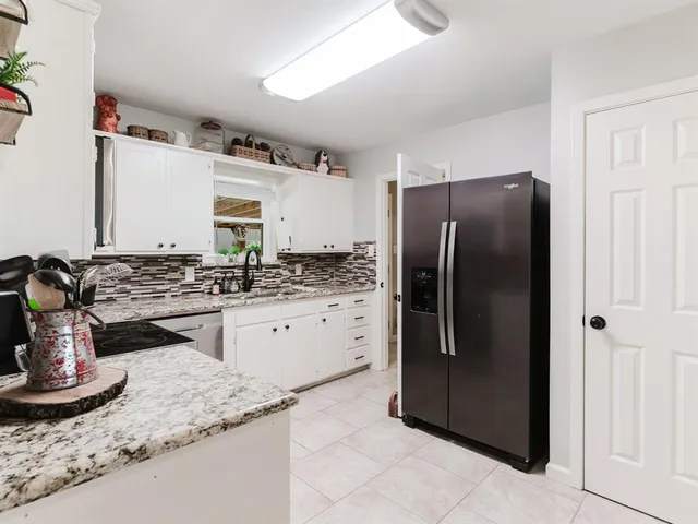 a spacious bedroom with a bed a couch and a flat tv screen