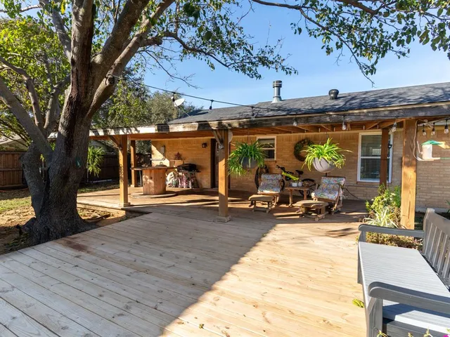 a view of a patio with table and chairs under an umbrella with wooden floor