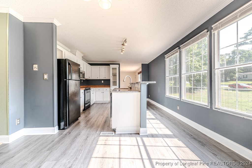 130 Box Elder Terrace Cameron, NC 28326 - Photo 13 of 43 a view of a kitchen with wooden floor and a refrigerator