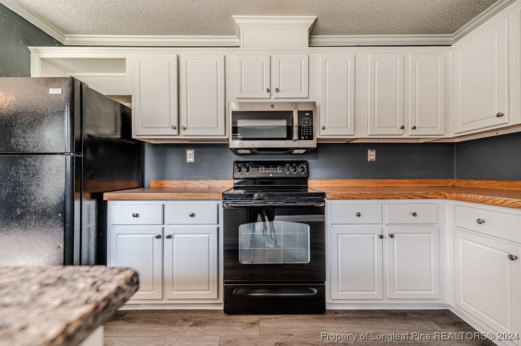 130 Box Elder Terrace Cameron, NC 28326 - Photo 9 of 43 a kitchen with stainless steel appliances granite countertop a refrigerator stove and white cabinets