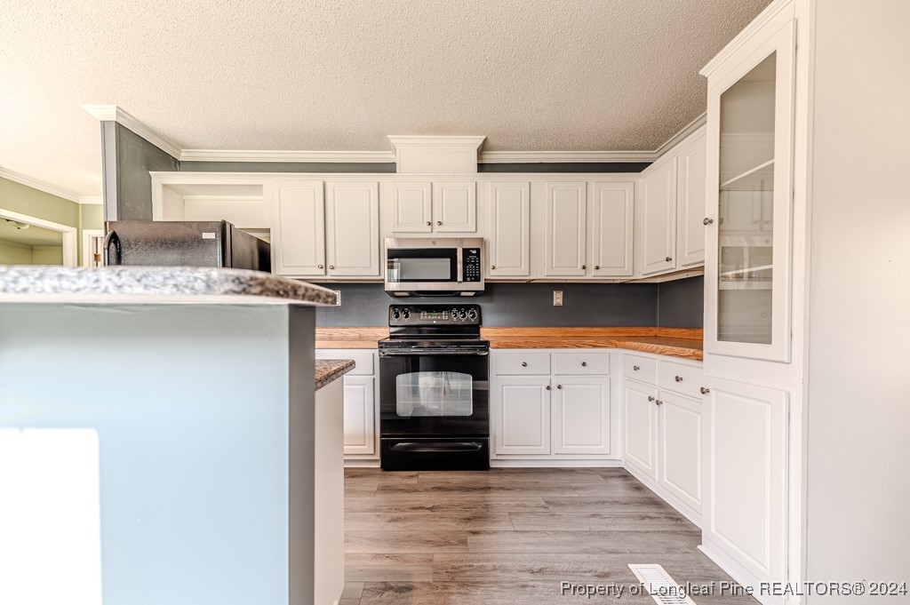 130 Box Elder Terrace Cameron, NC 28326 - Photo 10 of 43 a kitchen with granite countertop white cabinets and stainless steel appliances