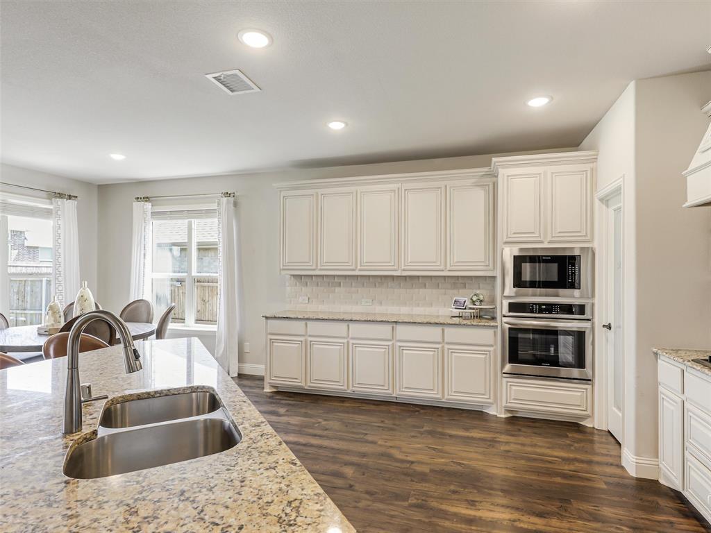 1216 Tree Shadow Lane Anna, TX 75409 - Photo 7 of 37 a kitchen with granite countertop a sink and a stove top oven