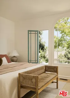 a bedroom with a bed and a large window
