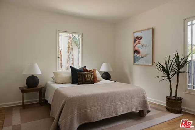 a bedroom with bed and a potted plant
