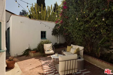 a view of a patio with couches table and chairs and potted plants
