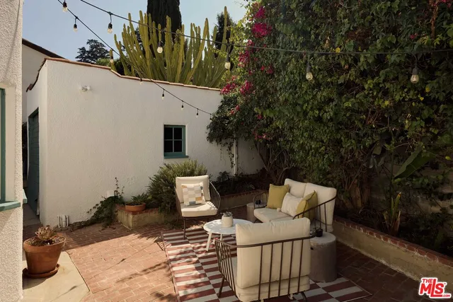 a view of a patio with couches table and chairs and potted plants