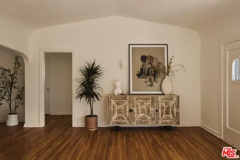 a view of a hallway with wooden floor and a potted plant