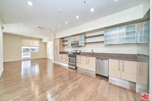 a kitchen with stainless steel appliances granite countertop a refrigerator and cabinets