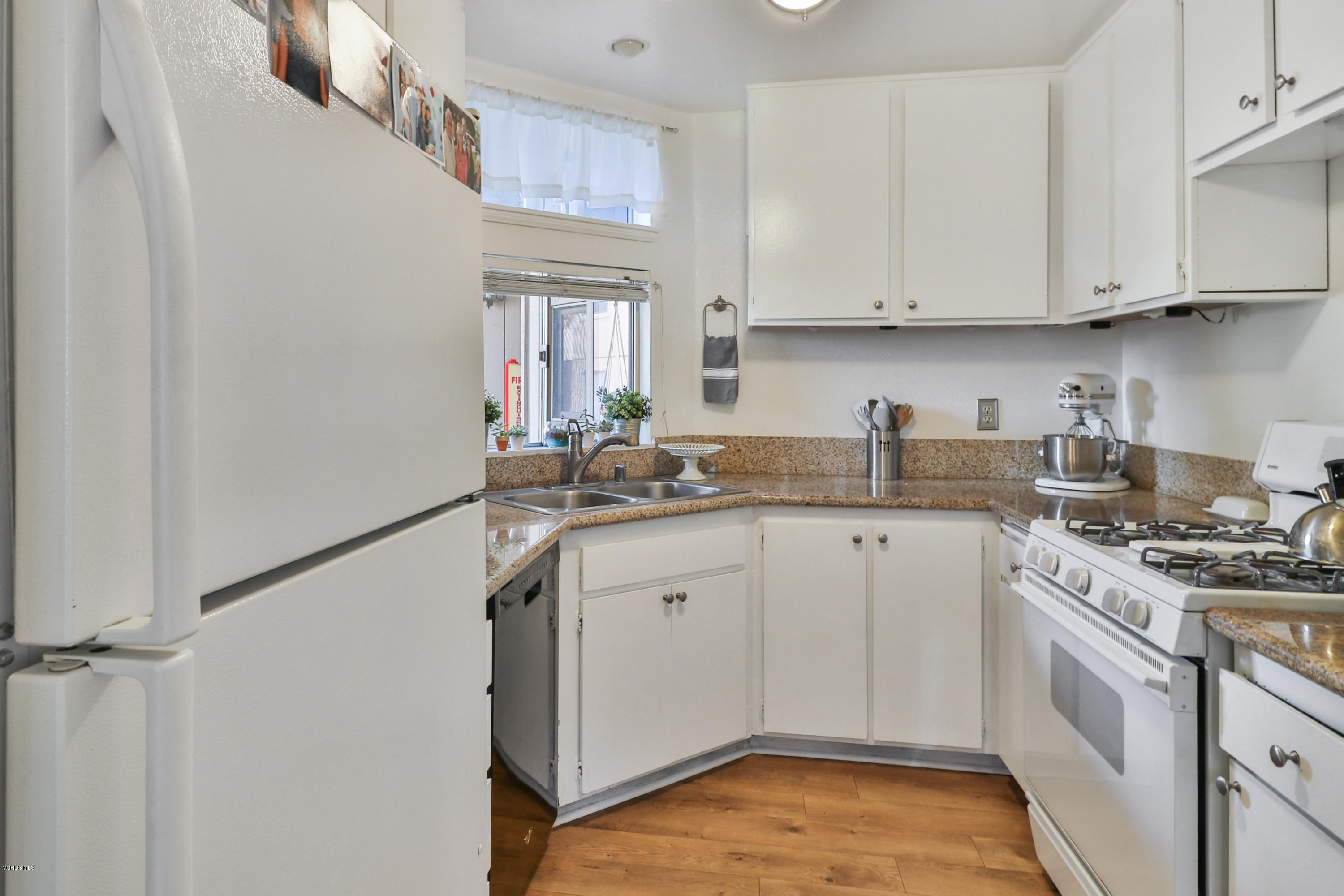 1778 Sinaloa Road, Unit 198 Simi Valley, CA 93065 - Photo 8 of 25 a kitchen with stainless steel appliances granite countertop a sink stove and white cabinets with wooden floor