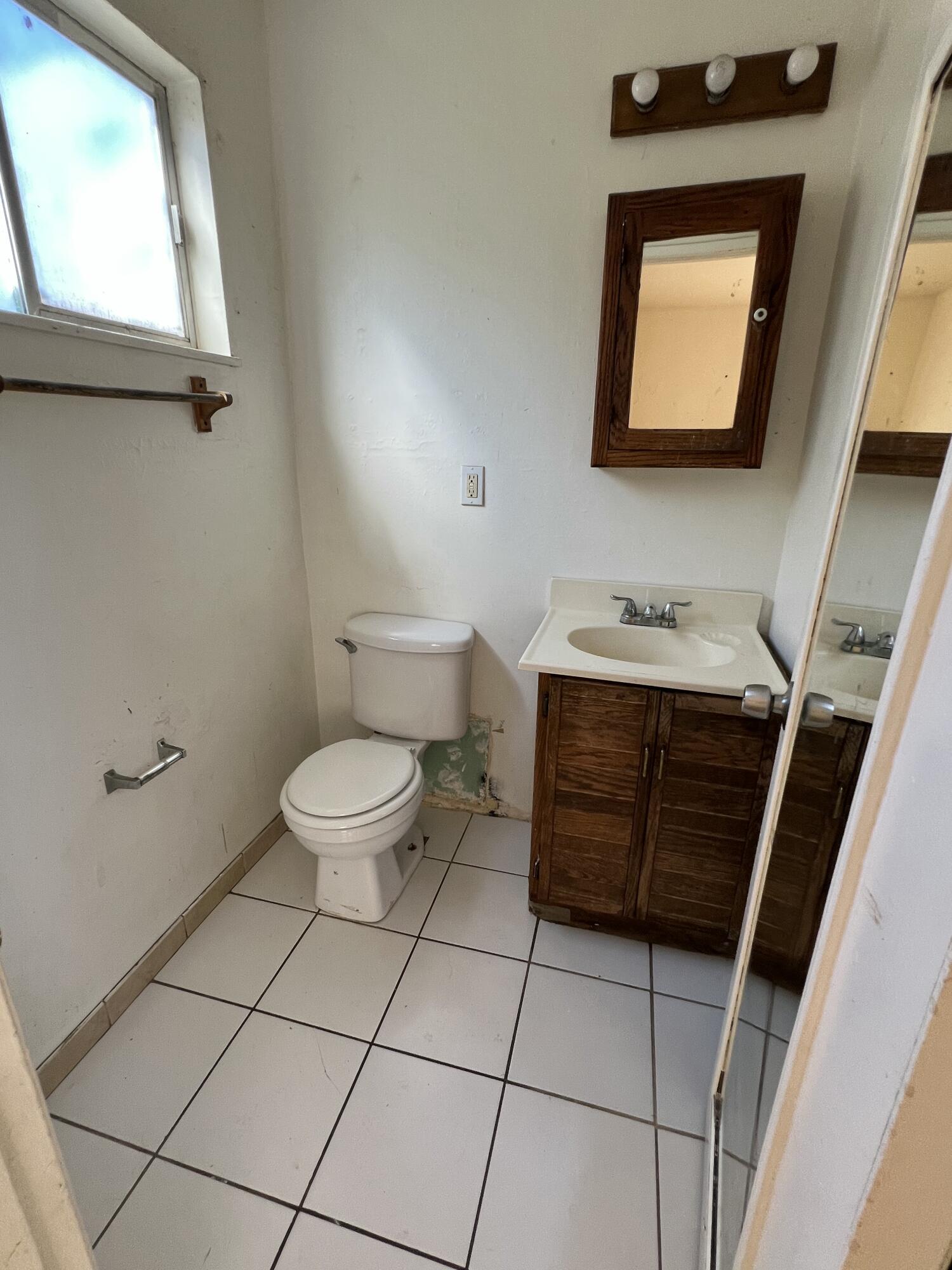309 V Street Lompoc, CA 93436 - Photo 14 of 24 a bathroom with a toilet a sink and mirror