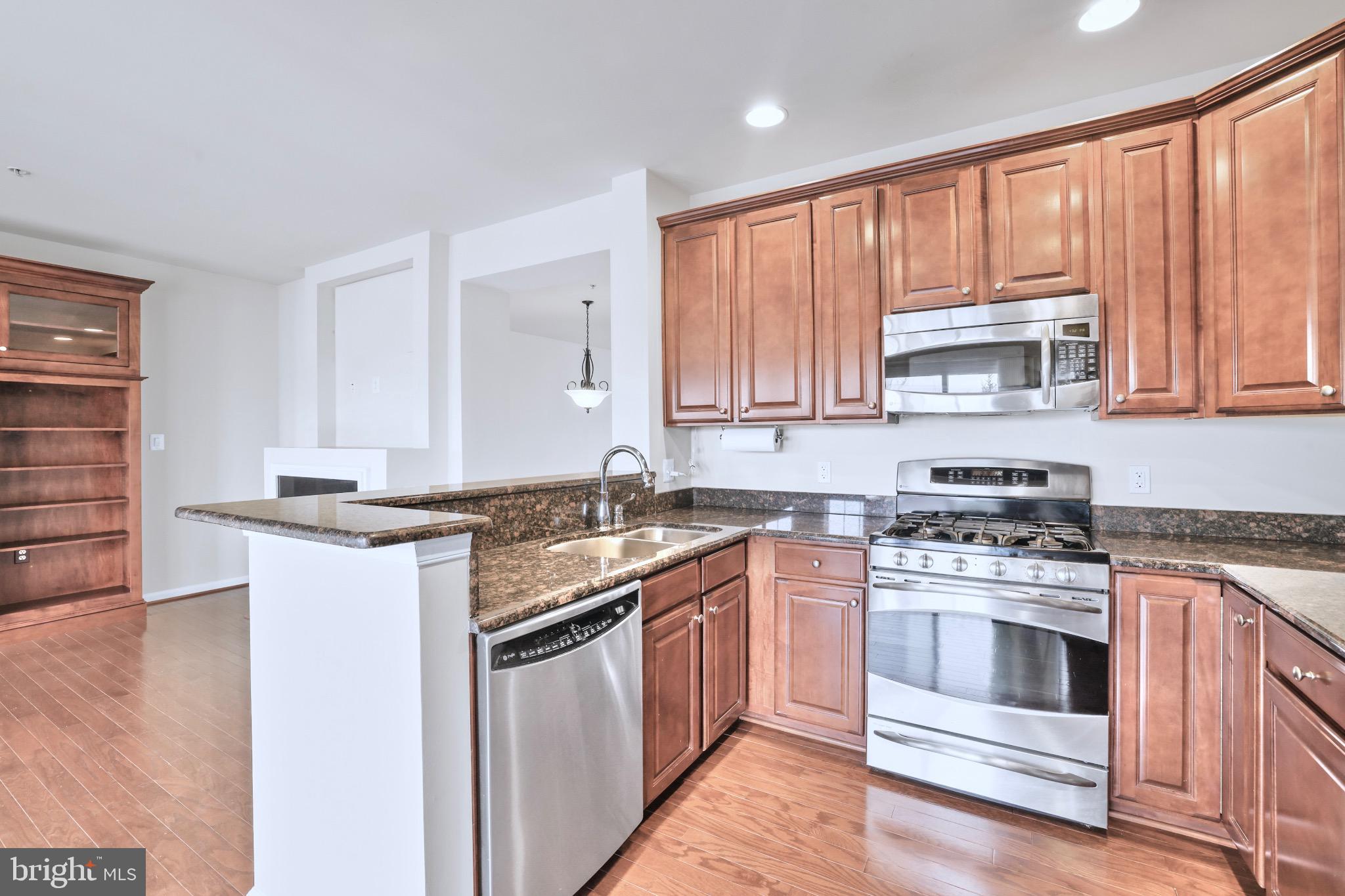 6055 Wicker Lane, Unit 128 Centreville, VA 20121 - Photo 13 of 36 a kitchen with stainless steel appliances granite countertop a stove sink and cabinets