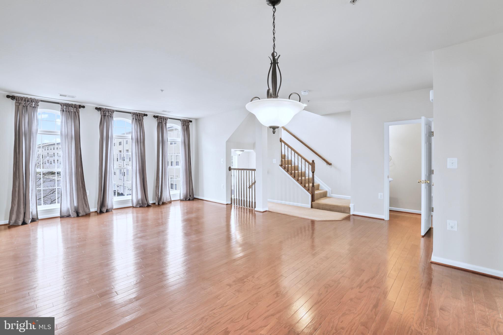 6055 Wicker Lane, Unit 128 Centreville, VA 20121 - Photo 4 of 36 a view of an empty room with wooden floor and stairs