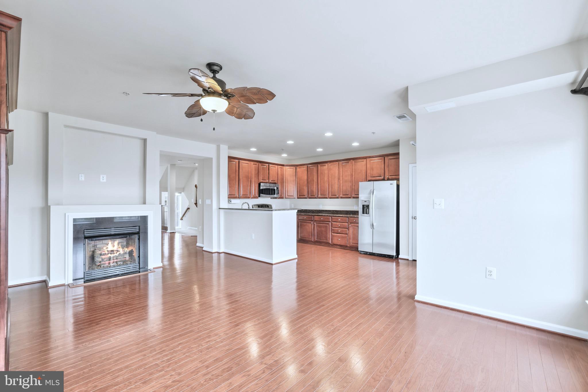 6055 Wicker Lane, Unit 128 Centreville, VA 20121 - Photo 5 of 36 a view of a livingroom with a fireplace a ceiling fan and wooden floor