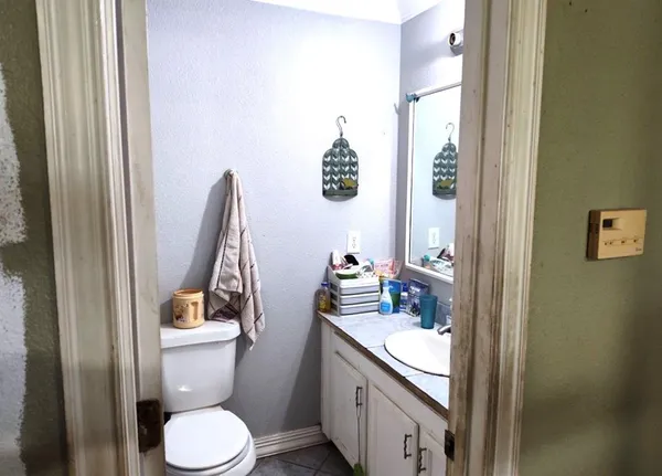 a bathroom with a granite countertop toilet sink and mirror