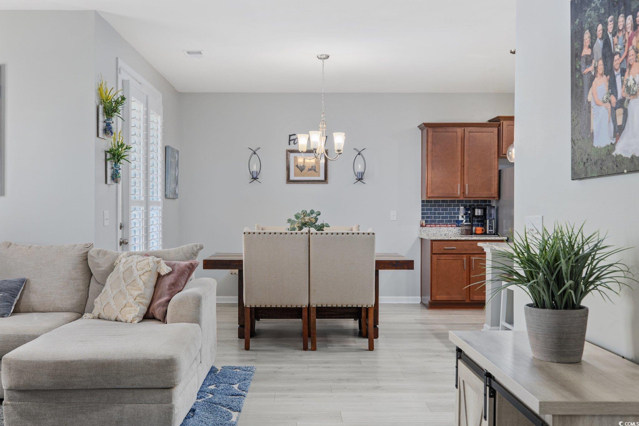 6009 Ranch View Drive Myrtle Beach, SC 29588 - Photo 15 of 40 Living room with light wood-type flooring, baseboards, an inviting chandelier, and visible vents