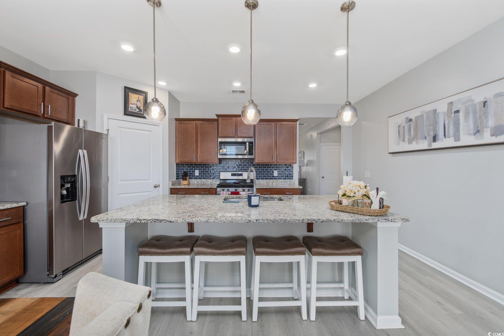 6009 Ranch View Drive Myrtle Beach, SC 29588 - Photo 6 of 40 Kitchen featuring a sink, stainless steel appliances, a kitchen breakfast bar, and backsplash