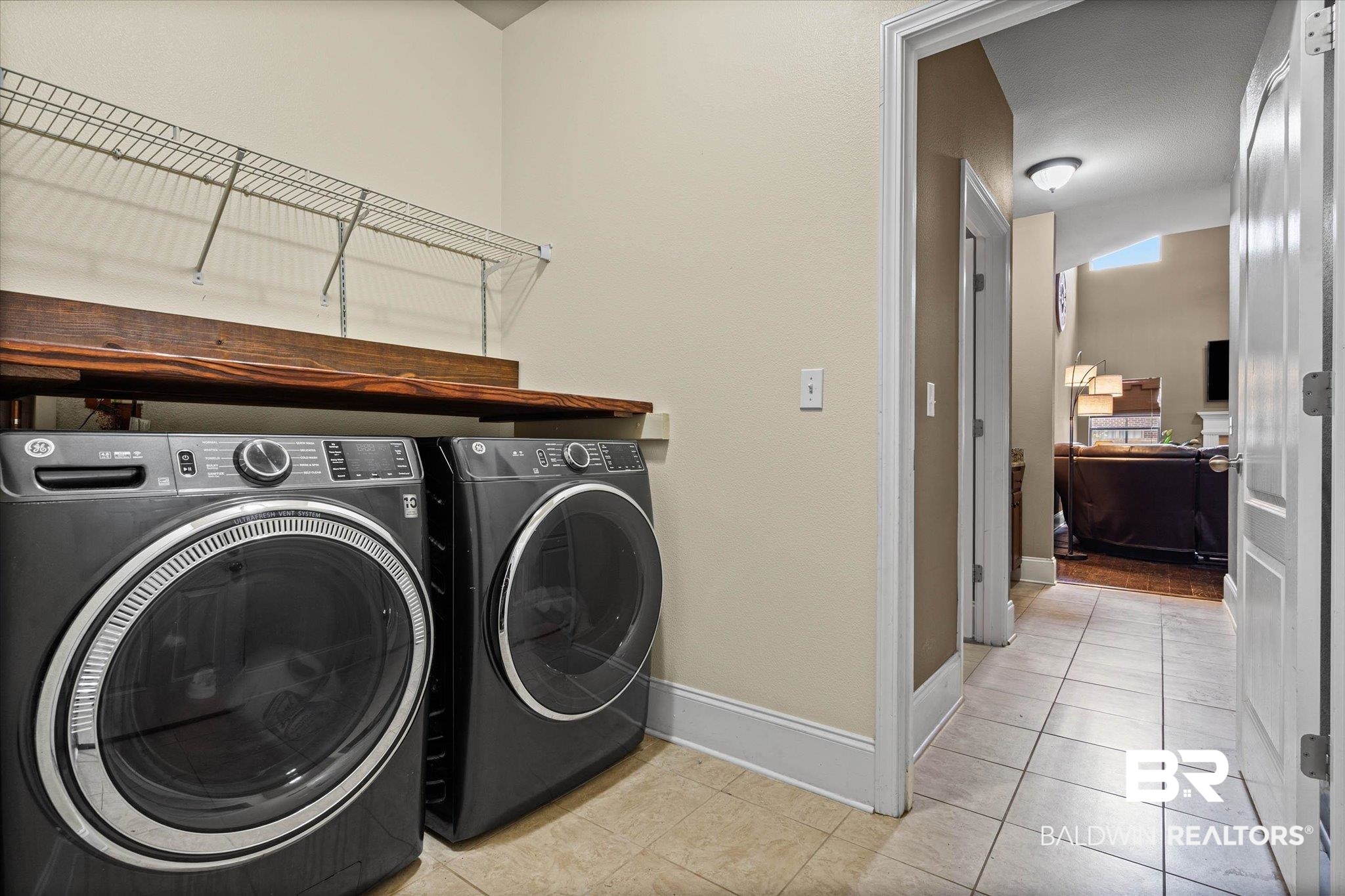 585 Sheffield Avenue Foley, AL 36535 - Photo 7 of 45 Dedicated laundry area featuring a wood-finish countertop, overhead wire shelving, and neutral wall tones