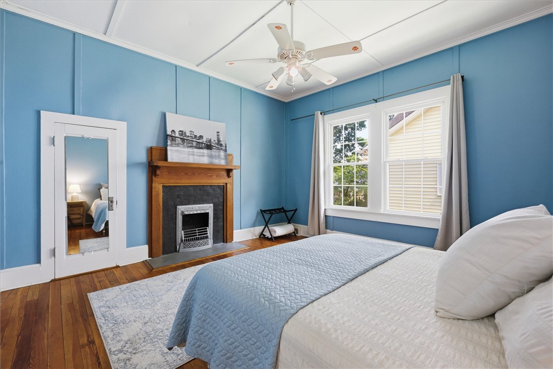 1104 Power Street Anderson, SC 29621 - Photo 19 of 34 Naturally illuminated bedroom with rich hardwood floors and an ornamental fireplace.