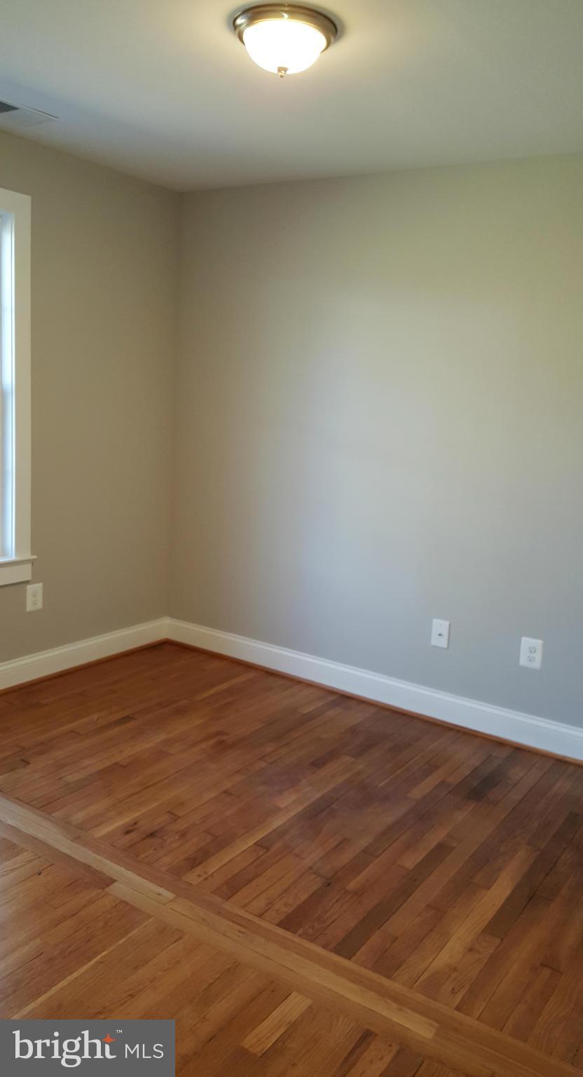 12101 Berry Street Silver Spring, MD 20902 - Photo 14 of 27 a view of an empty room with wooden floor and a window