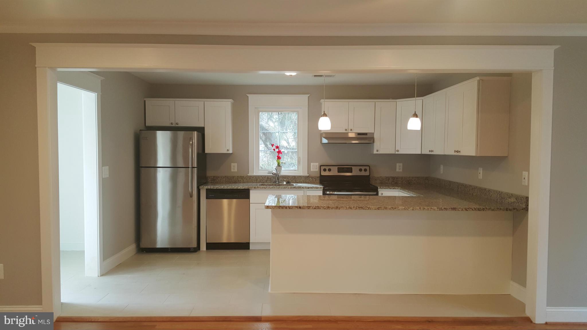 12101 Berry Street Silver Spring, MD 20902 - Photo 21 of 27 a kitchen with stainless steel appliances granite countertop a refrigerator a stove and a sink