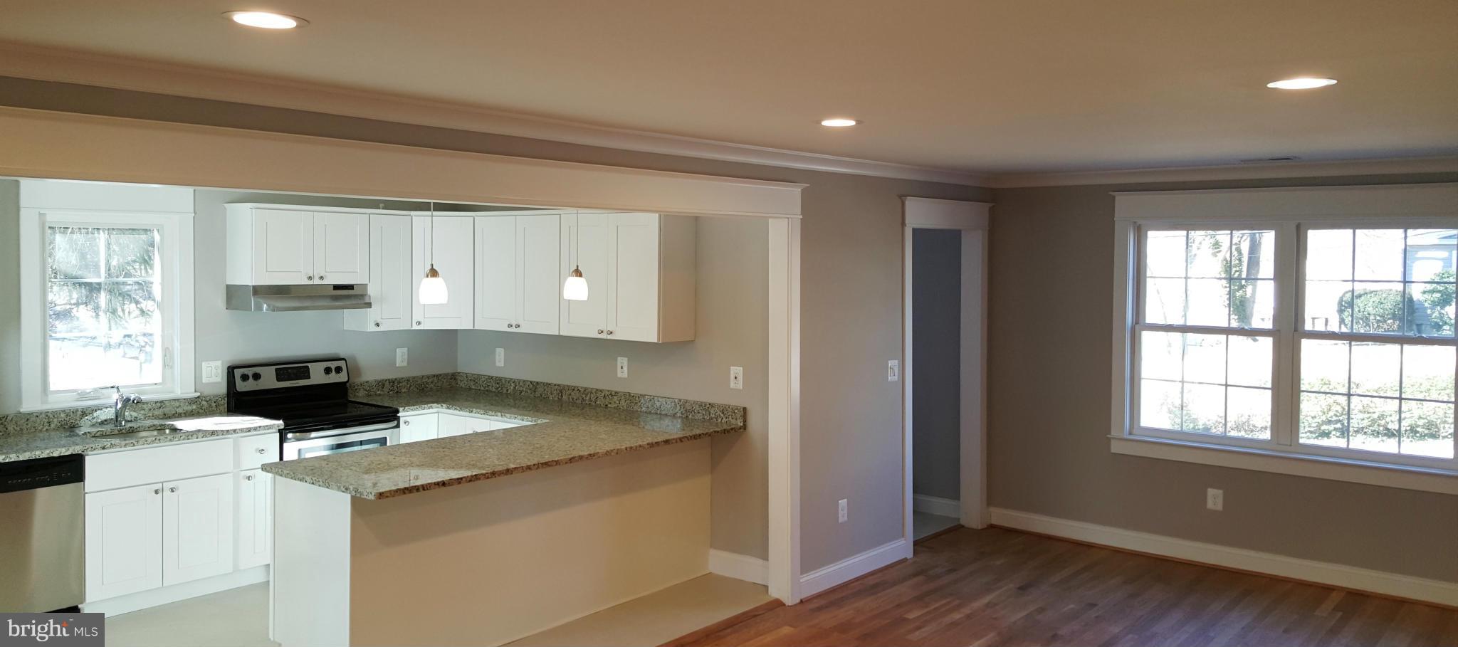 12101 Berry Street Silver Spring, MD 20902 - Photo 22 of 27 a kitchen with granite countertop a stove a sink and a microwave