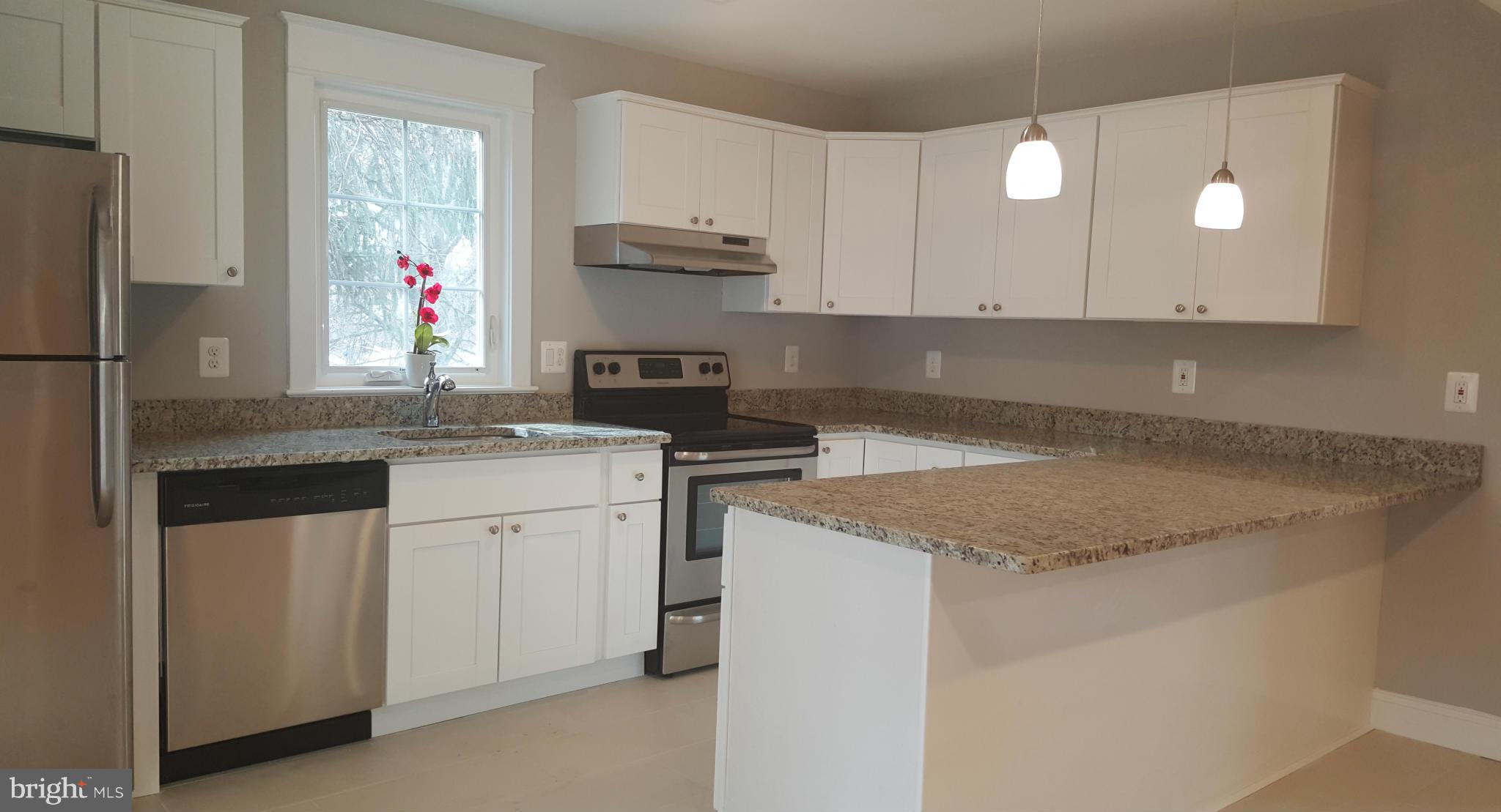 12101 Berry Street Silver Spring, MD 20902 - Photo 23 of 27 a kitchen with granite countertop white cabinets and white appliances
