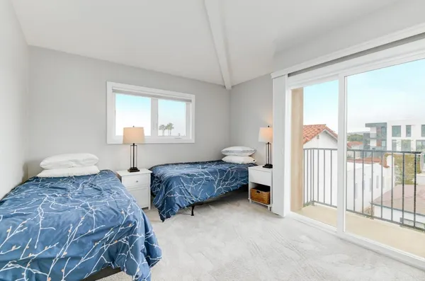 a bedroom with two beds and a large window