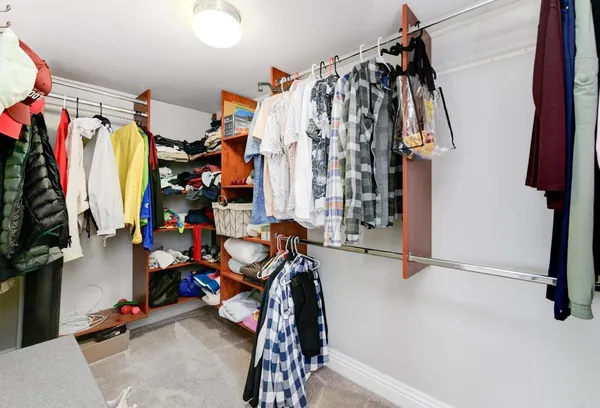 a view of walk in closet with clothes and shoes
