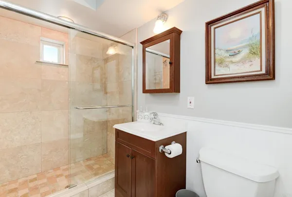 a bathroom with a sink mirror and a toilet