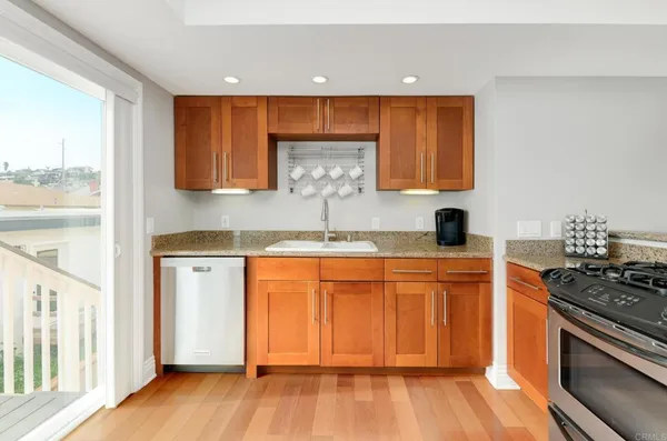 a kitchen with stainless steel appliances granite countertop a stove a sink and a microwave