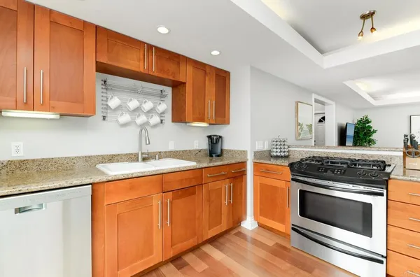 a kitchen with granite countertop wooden cabinets stainless steel appliances and a counter space