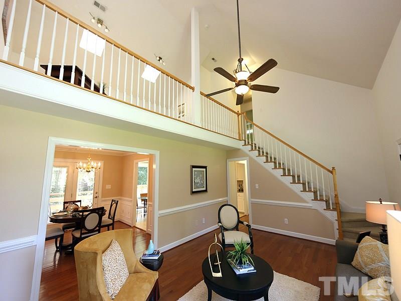 6825 Pinnacle Ridge Road Raleigh, NC 27603 - Photo 5 of 23 a living room with couches a fireplace and a dining table with wooden floor
