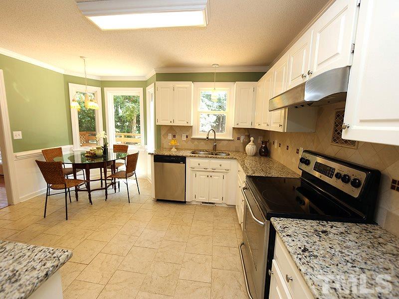 6825 Pinnacle Ridge Road Raleigh, NC 27603 - Photo 9 of 23 a kitchen with a stove a sink a counter top space and cabinets