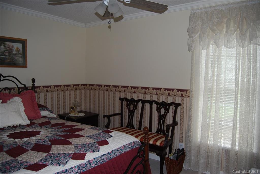 100 Hampton Road, Unit 13 Leicester, NC 28748 - Photo 14 of 33 a bed sitting in a bedroom next to a window and a chandelier