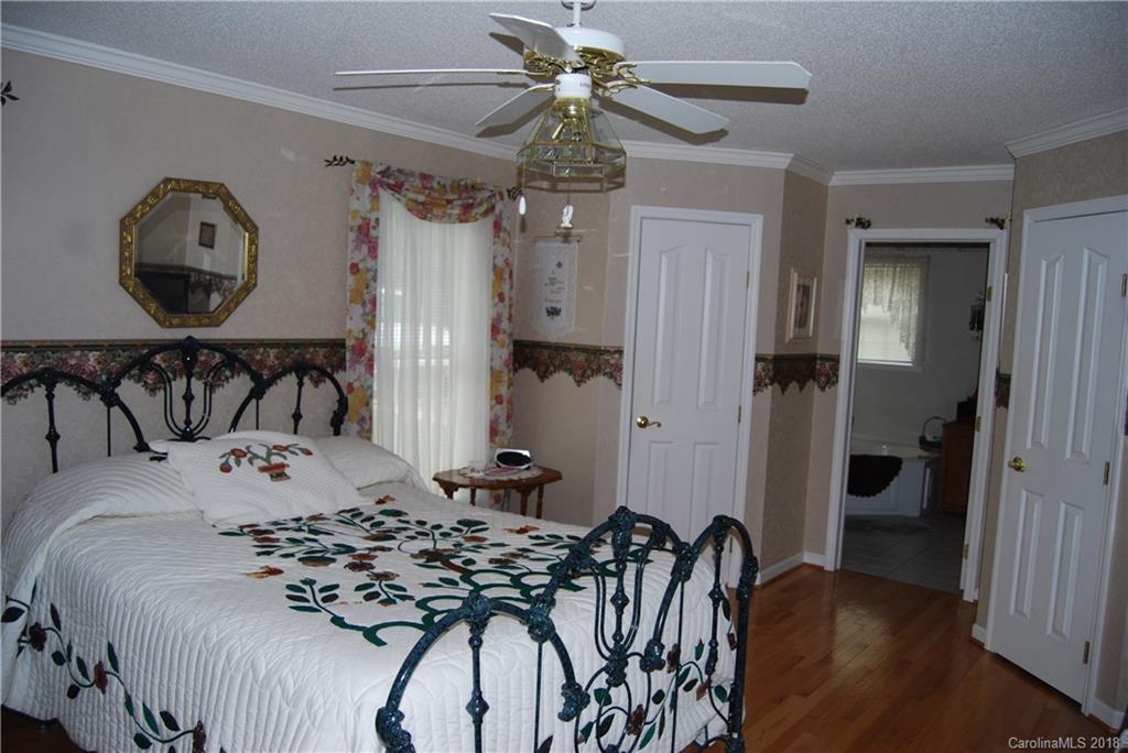 100 Hampton Road, Unit 13 Leicester, NC 28748 - Photo 8 of 33 a bedroom with furniture and a chandelier