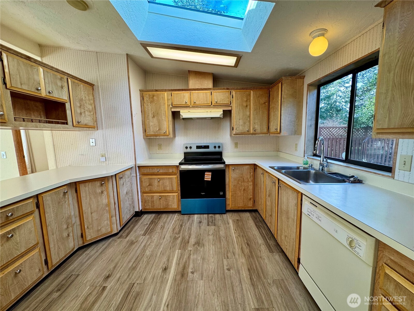 120 Fircrest Drive Sequim, WA 98382 - Photo 15 of 32 a kitchen with stainless steel appliances wooden floors and wooden cabinets
