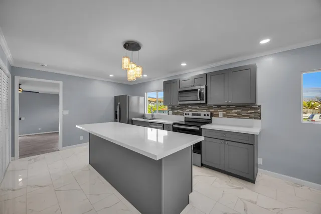 a kitchen with kitchen island a sink stainless steel appliances and cabinets
