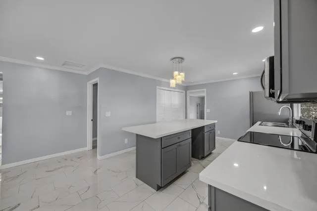 a kitchen with a sink a stove top oven and cabinets