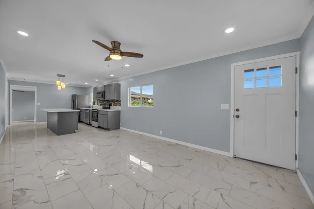 a view of a kitchen with a stove cabinets a ceiling fan and wooden floor