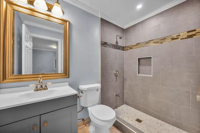 a bathroom with a sink a toilet a mirror and shower