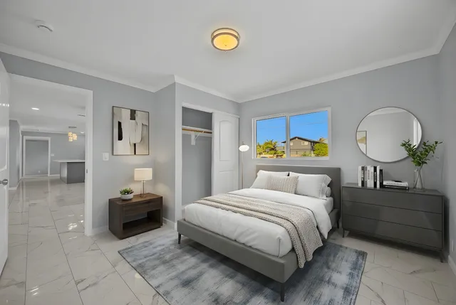 a bedroom with a bed mirror and a window