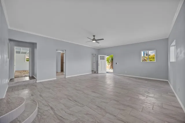 a view of an empty room with window and wooden floor