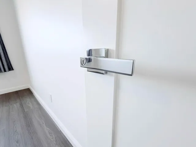 an empty room with wooden floor and fan