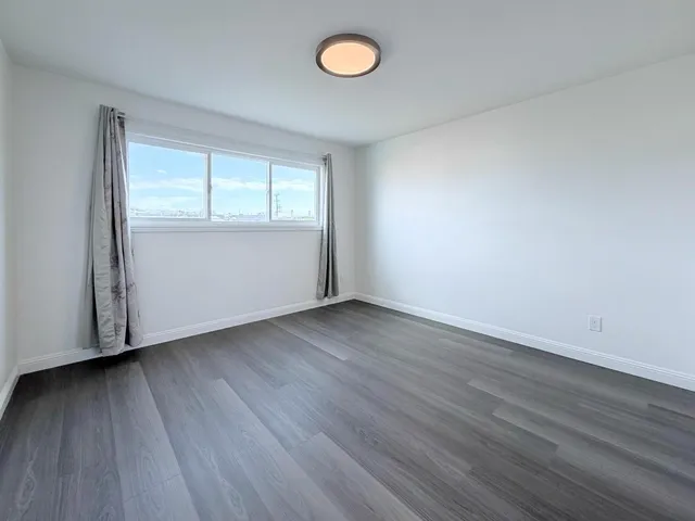 a view of a room with wooden floor